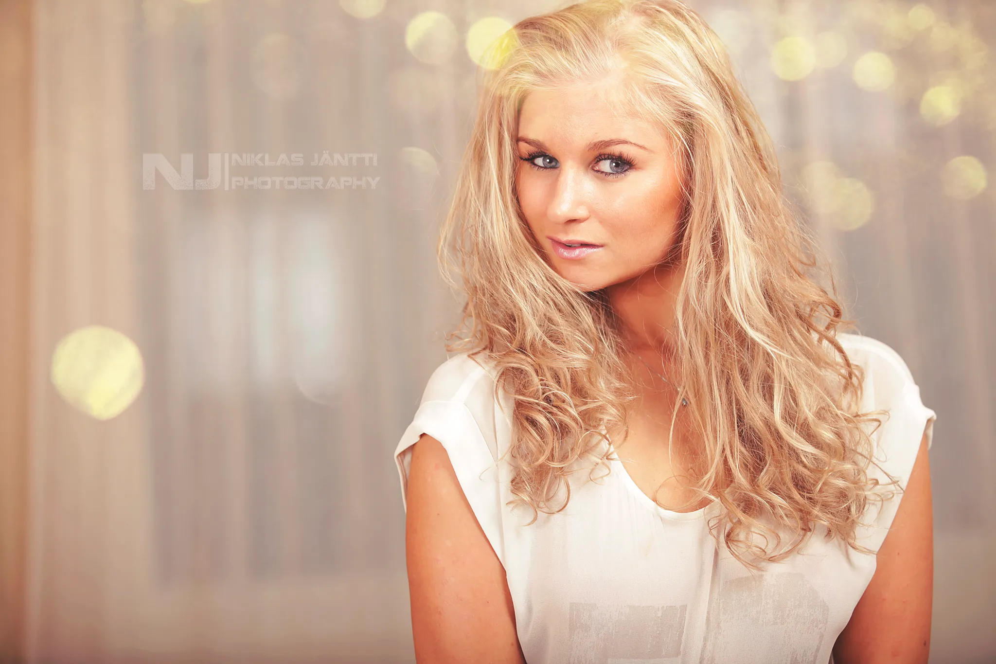 Ruth in soft-focus portrait wearing white blouse and wavy hair