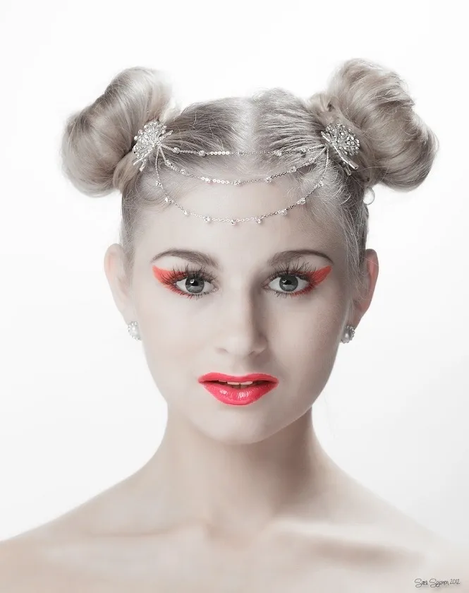 Ruth with avant-garde space buns, crystal headchain and bold coral makeup