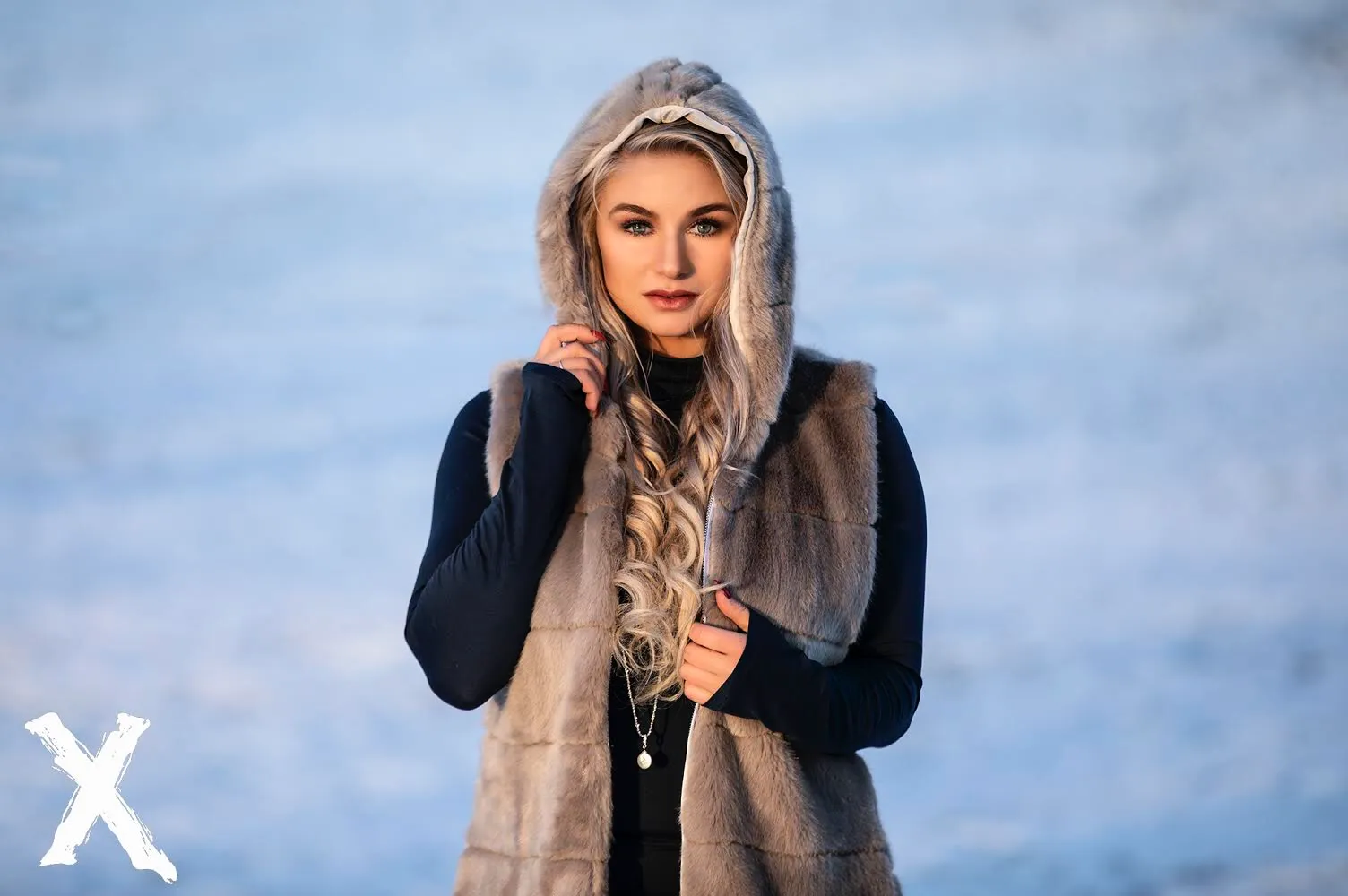 Ruth in fur-hooded vest against snowy winter landscape