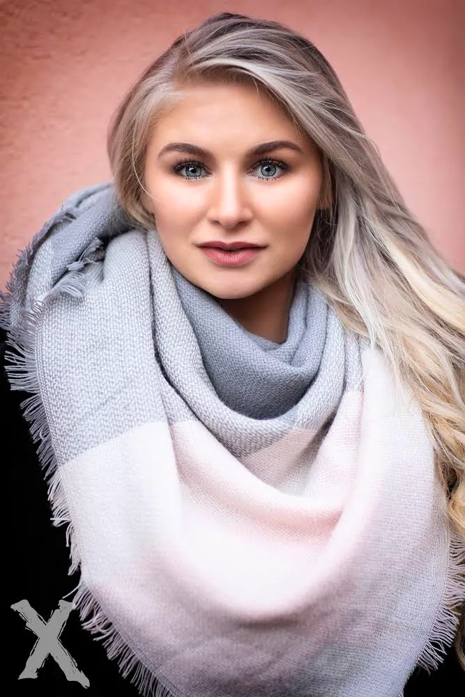 Ruth in cozy scarf close-up, soft pink background beauty shot