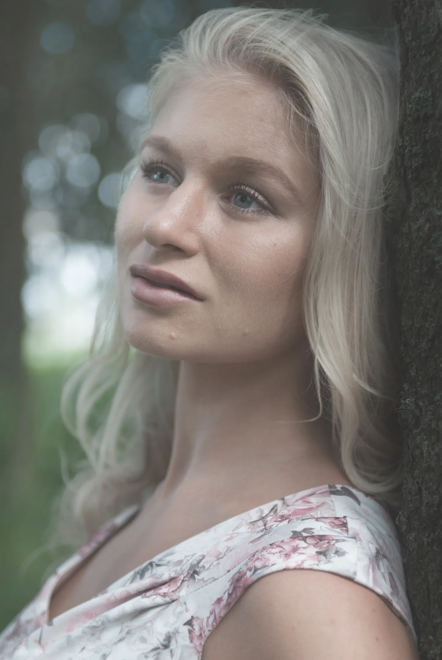 Ruth in close-up against tree with floral dress, soft natural light