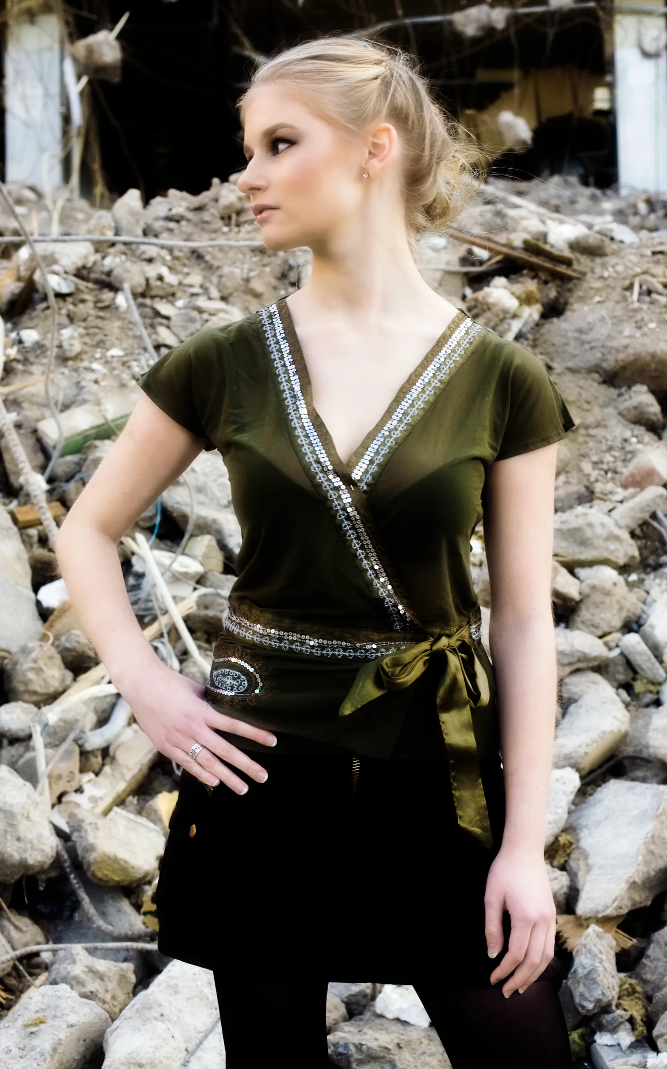 Ruth in sequined olive top posing at demolished site