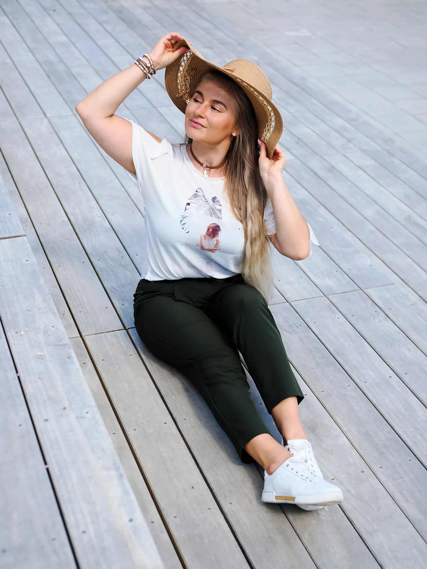 Ruth sitting on wooden deck with straw hat, summer relaxed mood