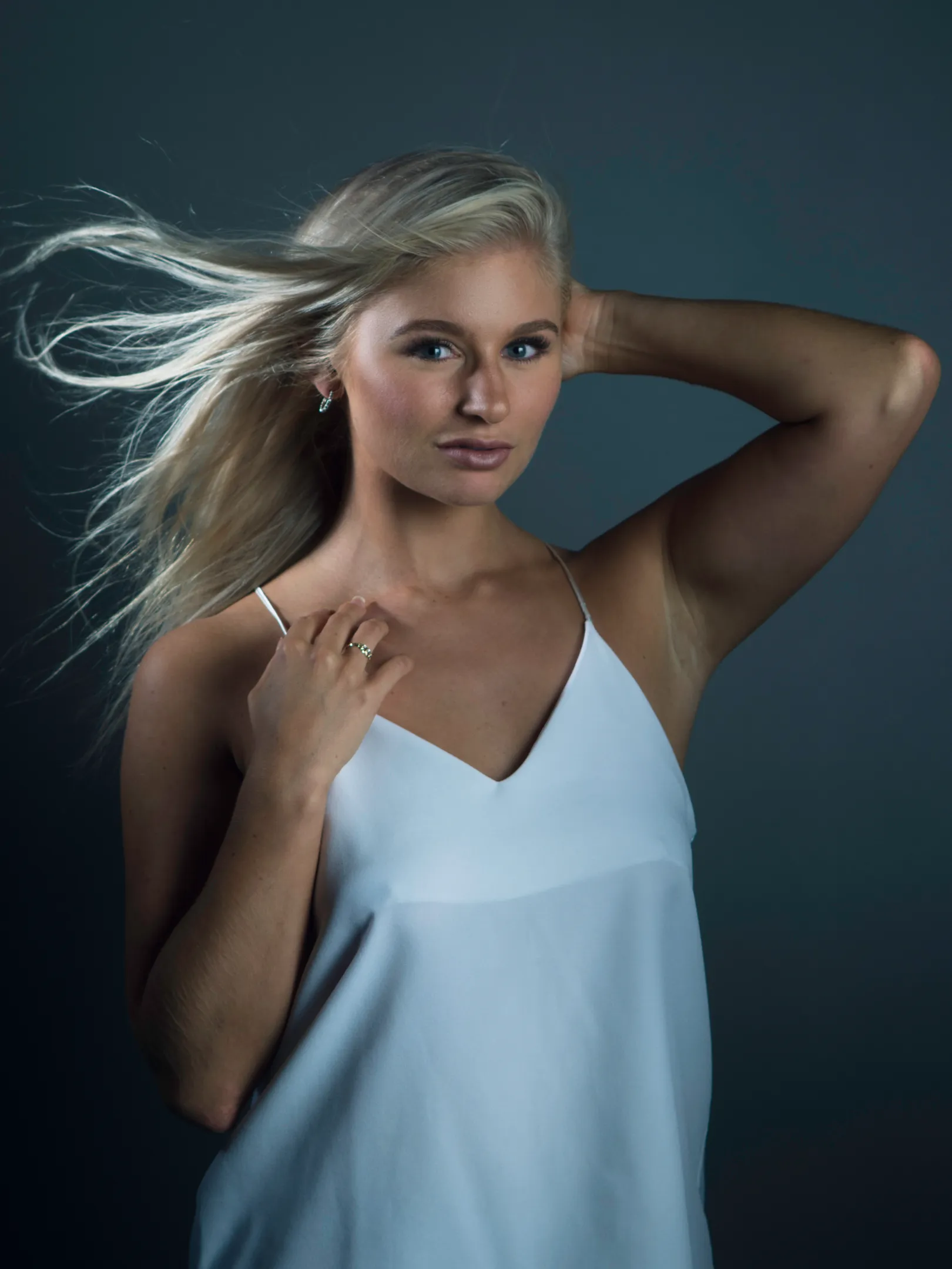 Ruth in windblown white camisole with teal studio backdrop