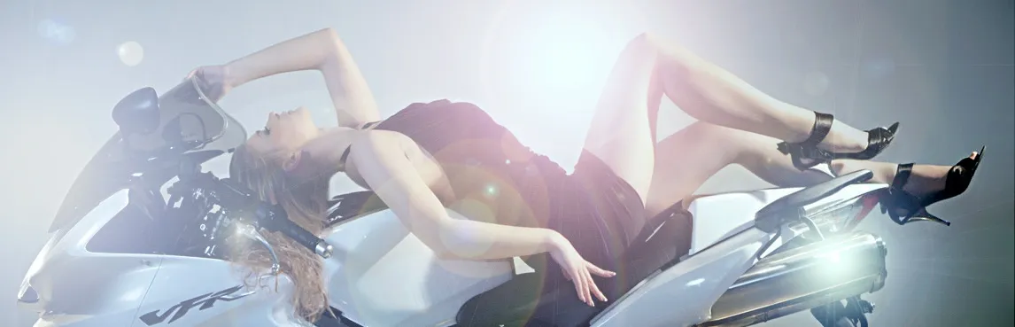 Ruth reclining on motorcycle in dramatic haze and lens flare