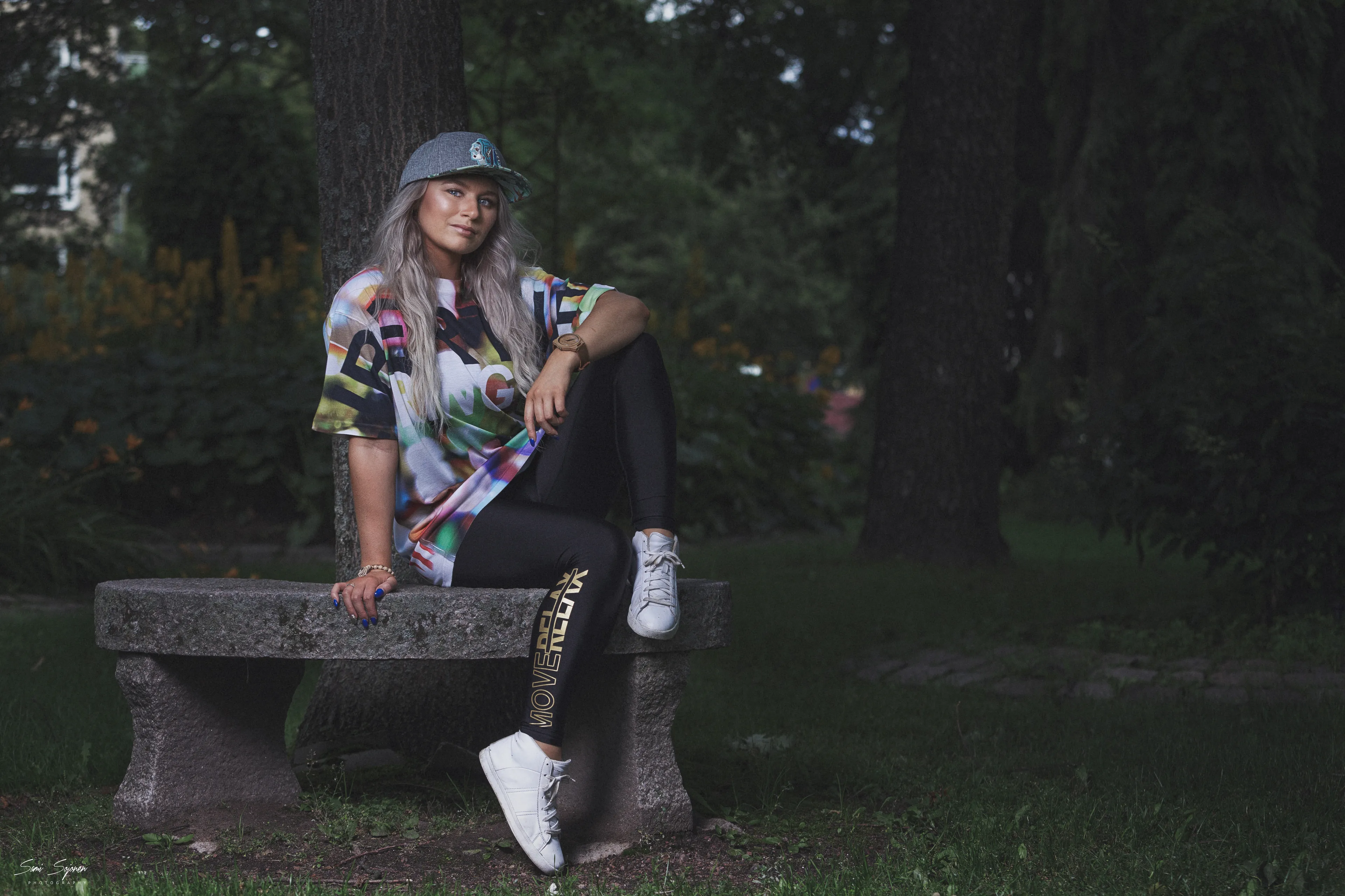 Ruth in graphic streetwear on park bench, relaxed urban portrait