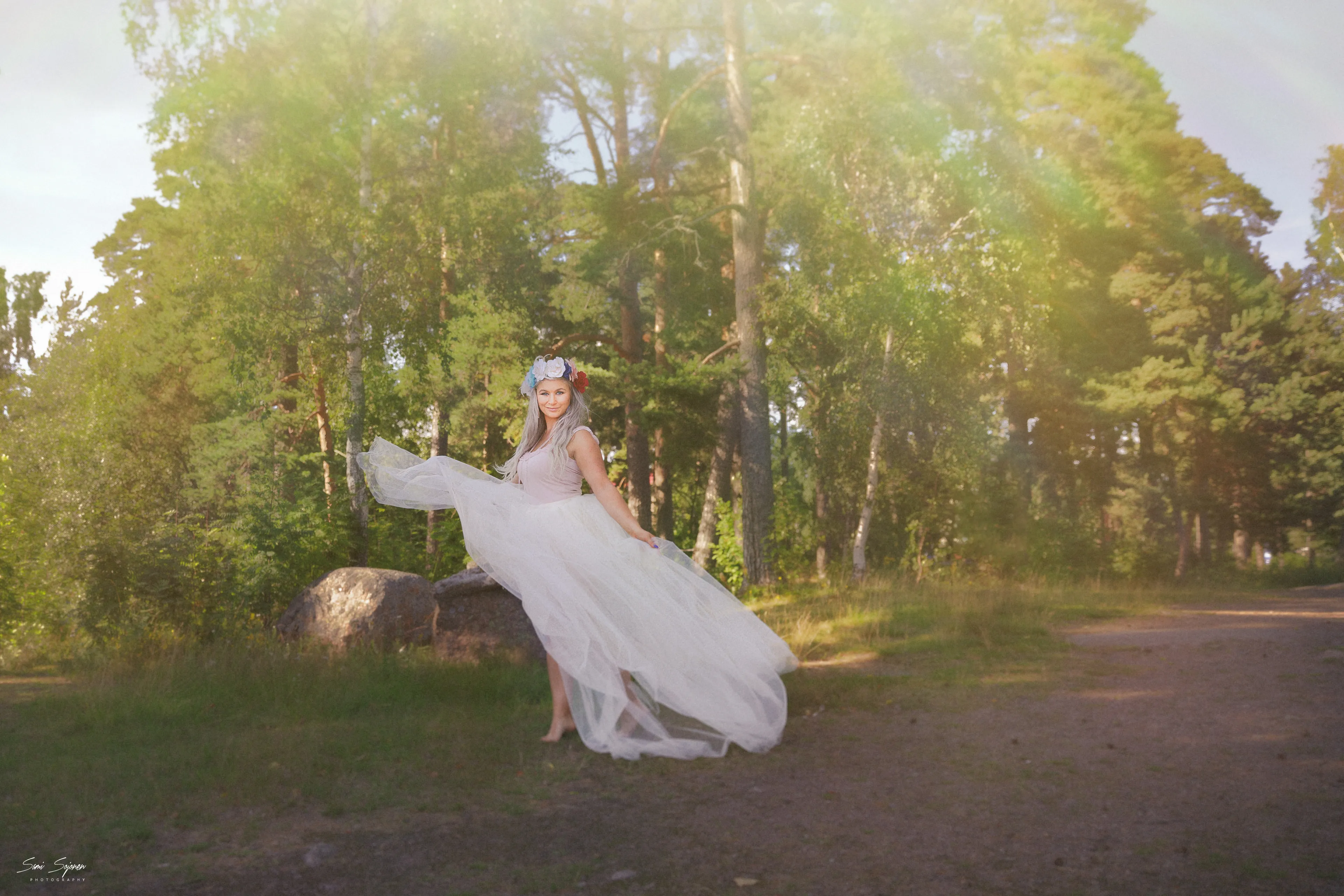 Ruth twirling tulle dress on forest path in sun-dappled light