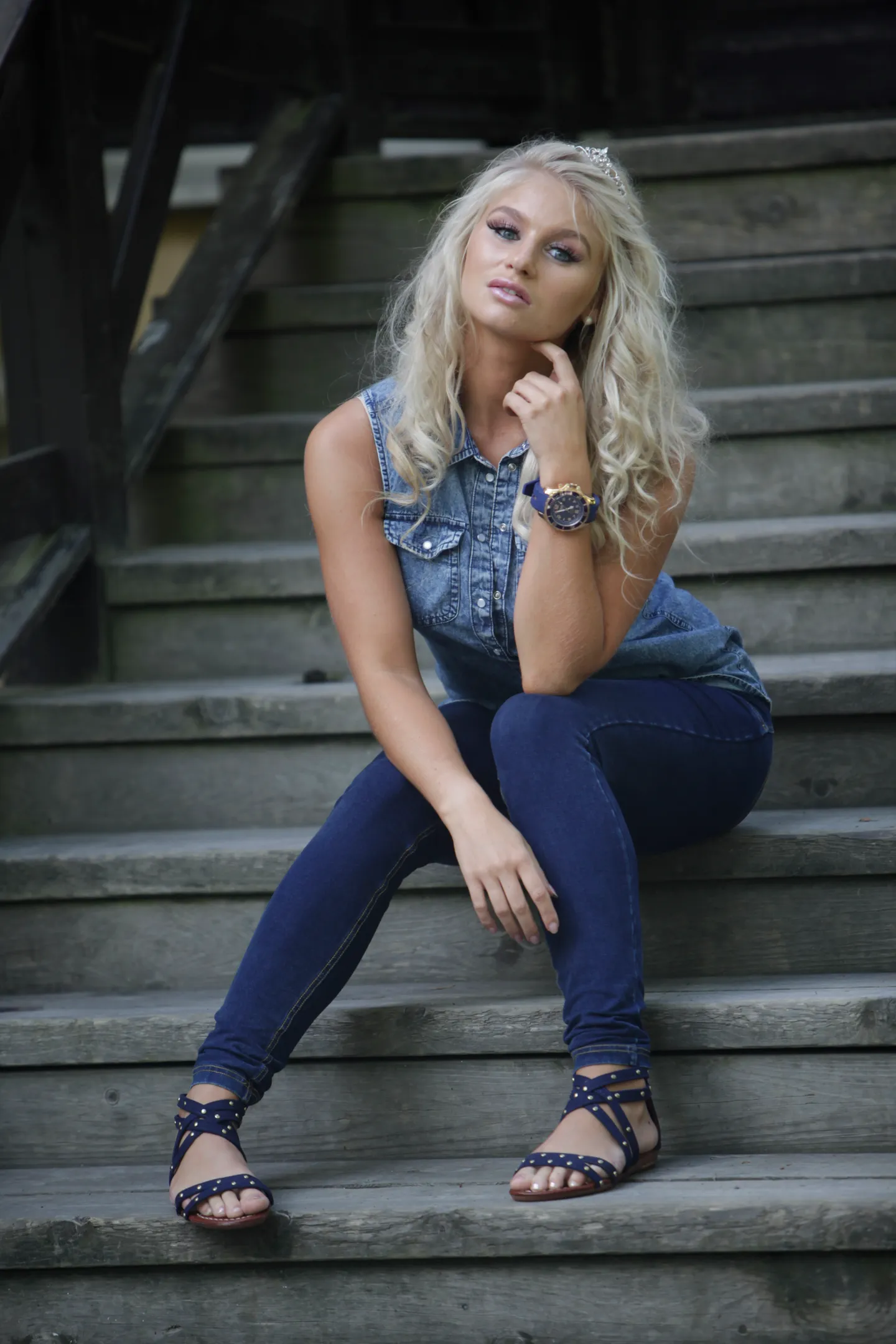 Ruth on wooden staircase in casual denim, relaxed outdoor pose