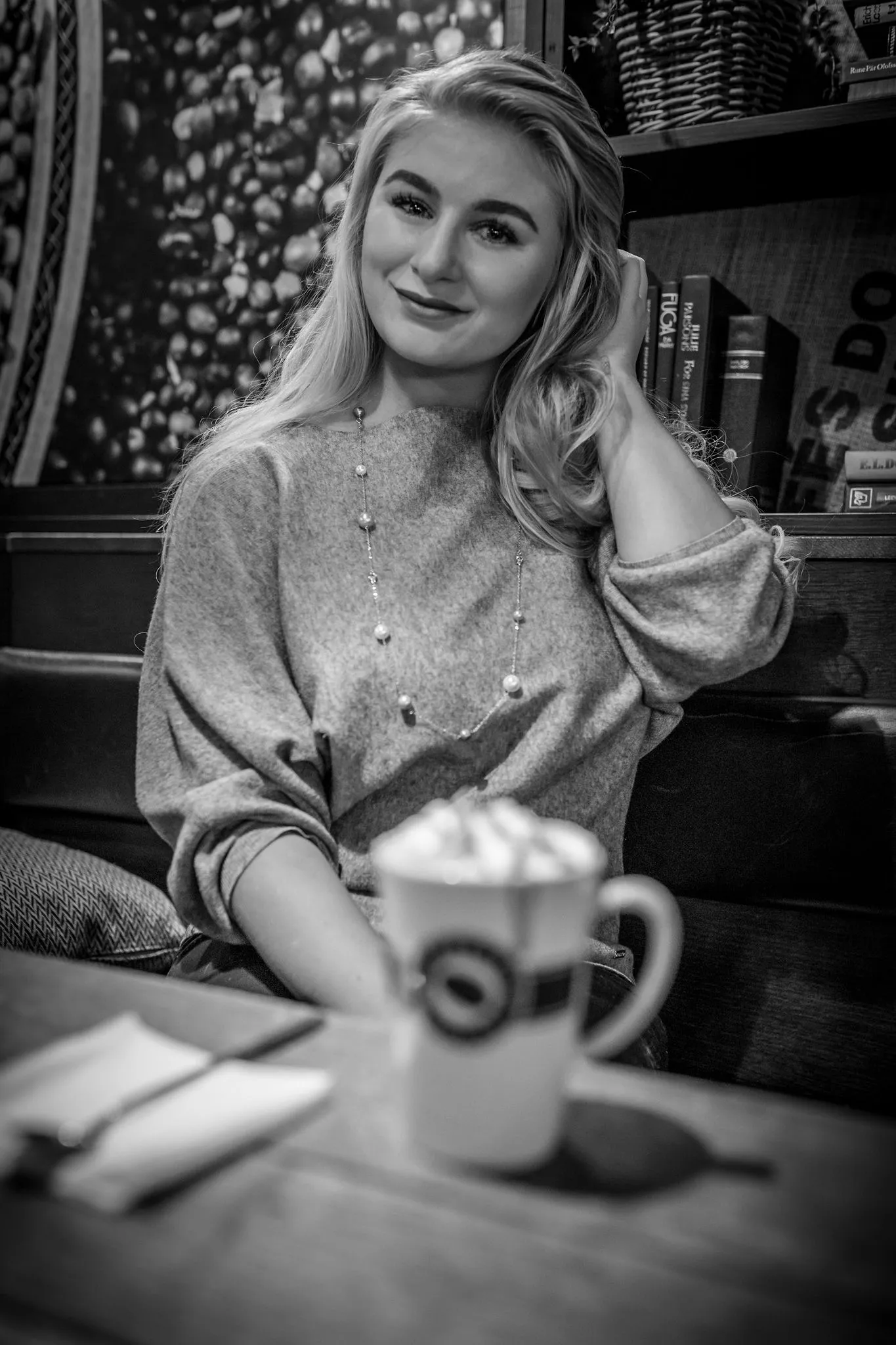 Ruth smiling at cafe table with latte, casual portrait