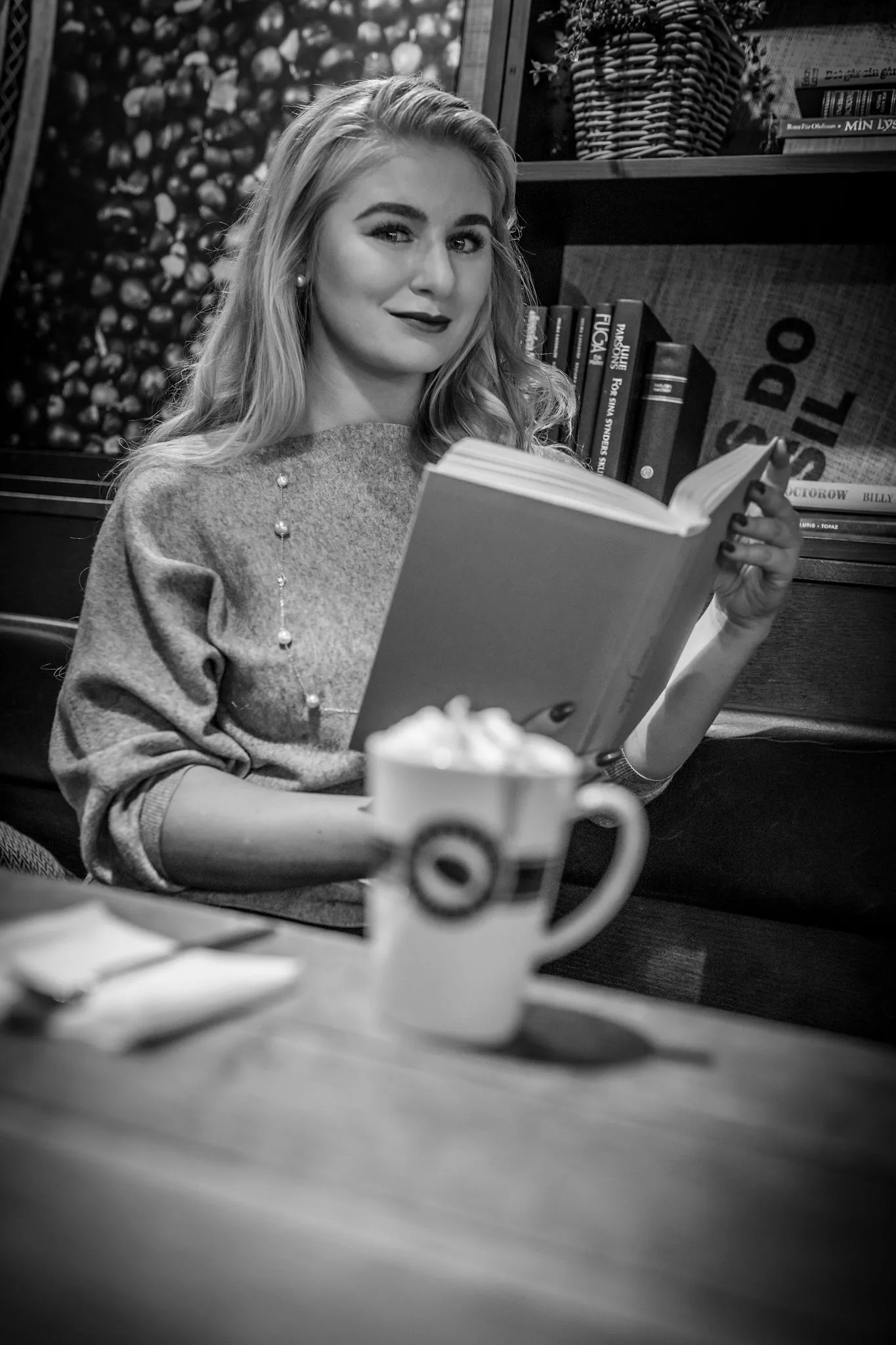 Ruth reading book at cafe with latte, relaxed lifestyle