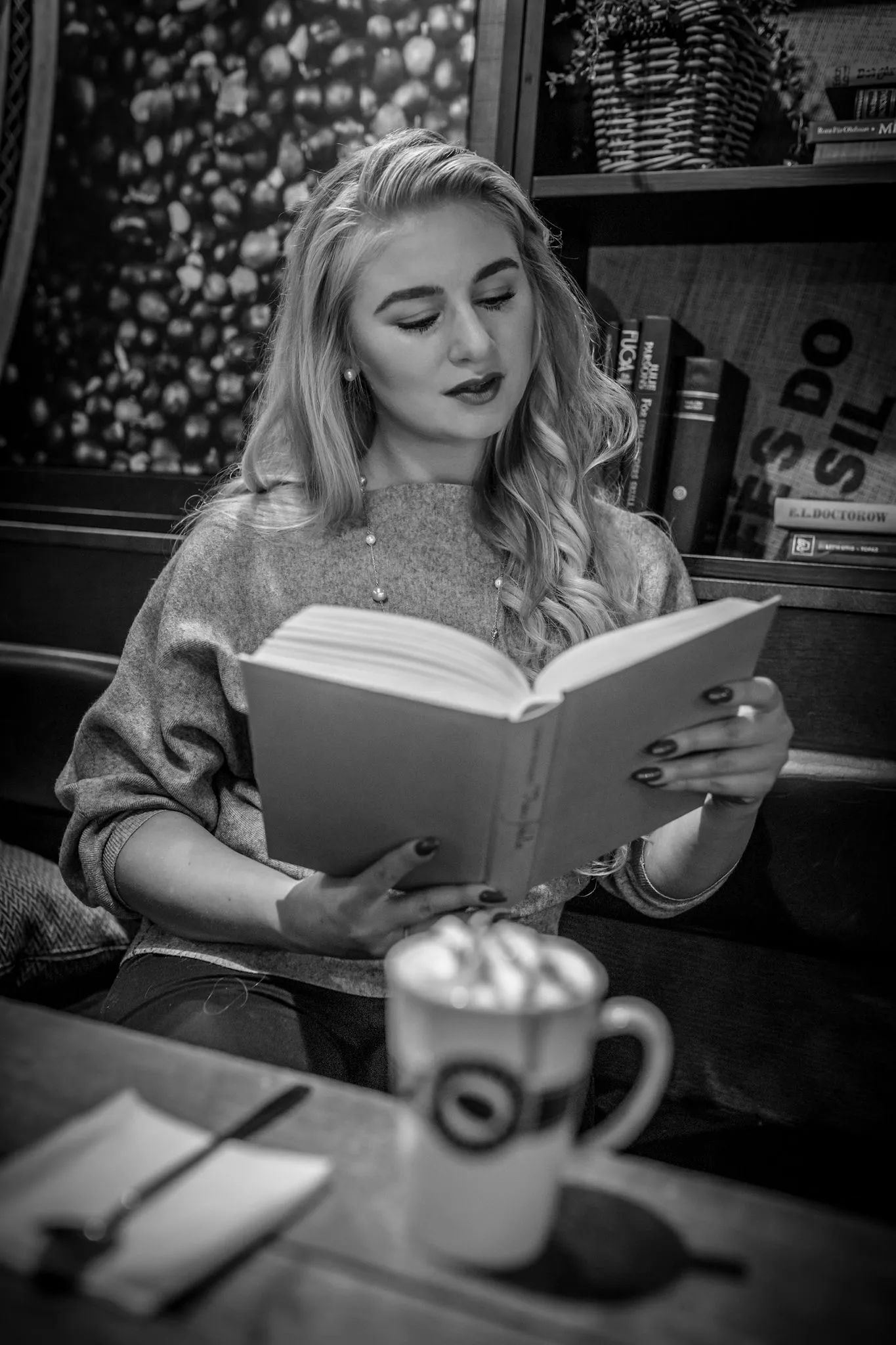Ruth absorbed in reading at cafe, candid black and white